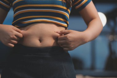 Şişman karnına dokunup sıkarken çekilmiş bir fotoğraf..