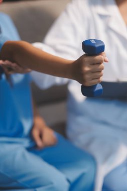 Tanımlanamayan fiziksel terapi sırasında mavi el ağırlığı kullanır