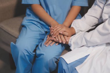 Görüntüleri kapatın, doktor hastaya tavsiye vermek ve hastalıkla mücadeleyi teşvik etmek için el ele tutuşuyor ve yaşlı hastalara ve sağlık hizmetleri konseptine destek oluyor..