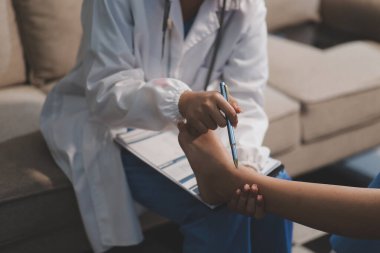 Kadın bir doktor, eklem iltihabı nedeniyle diz ağrısı olan yaşlı bir hastayı muayene eder. Hastaya iyileşme sürecinde yardım ediliyor, ağrı yönetimi ve hareket kabiliyetinin iyileştirilmesi üzerinde duruluyor..