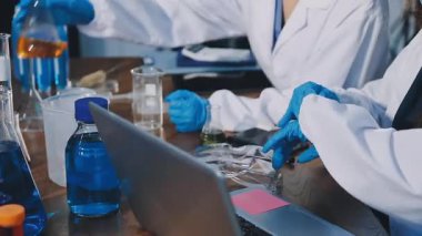 Yakın çekim. Laboratuvarda bir kimyasal testle çalışan bilim adamı..