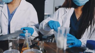 İki bilim adamı laboratuvarda kimyasal test yapıyor.