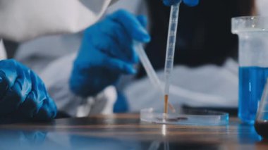 Üniformalı bir laboratuvar çalışanı test yapıyor.