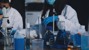 Laboratuvarda mikroskoplu genç bir kadın.