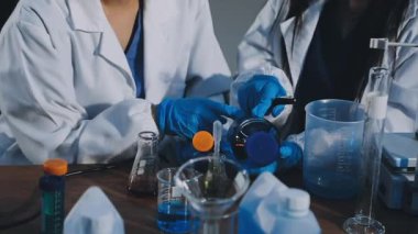 Arka planda laboratuvarda çalışan iki bilim adamının yakın görüntüsü..