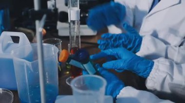 Laboratuvar asistanı laboratuarda test tüpleriyle çalışıyor..