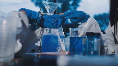 Laboratuarda kimyasal ekipmanlarla çalışan genç bir bilim adamı.