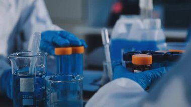 Bilim adamı deney tüpünü sıvı ile tutuyor