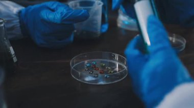 Mavi bir tüp ve bir bardak su tutan bir elin yakınına.