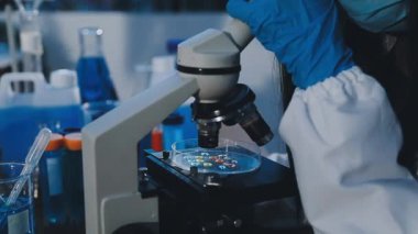 Laboratuvarda mikroskop kullanan kadın bilim adamı