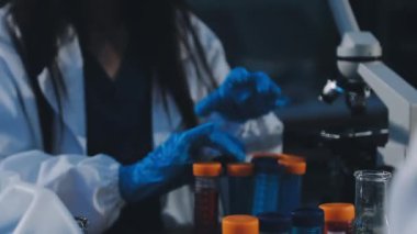 Bilim adamı laboratuarda sıvı tüpü tutuyor..