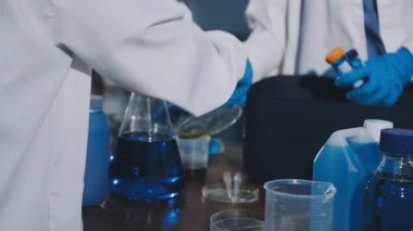 Laboratuvarda kimyasal çözeltisi olan test tüpü tutan erkek bilim adamının yakın çekimi.