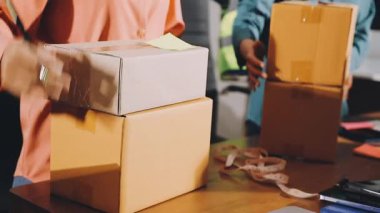 Beyaz gömlekli bir adam elinde karton bir paketle dizüstü bilgisayar üzerinde çalışıyor. Teslimat hizmeti kavramı. İnternetten alışveriş. Çevrimiçi dağıtım hizmeti kavramı