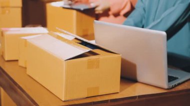 Ofiste dizüstü bilgisayarı ve kutuları olan kadın eli. çevrimiçi alışveriş.