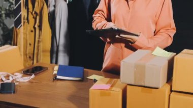 Mağazada karton kutu paketleyen bir kadın. Online alışveriş, çevrimiçi alışveriş, teslimat, dağıtım hizmeti