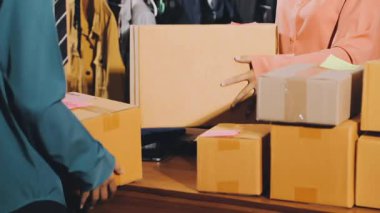 Depoda elinde karton kutularla bir kadın var.
