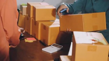 Teslimat. Genç Asyalı üniformalı adam ofiste karton kutularla çalışıyor..
