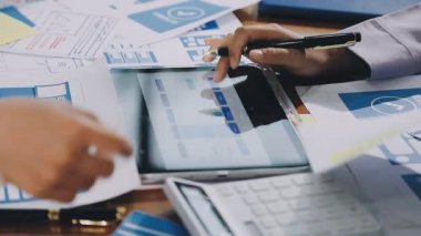 Ekonomik verileri hesaplamak ve ofisteki bilgisayardaki verileri analiz etmek için hesap makinesi kullanan işadamlarının kapatılması