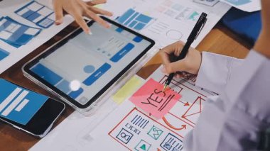 Ofis masasında dijital tabletli cep telefonu kullanan bir iş kadını.