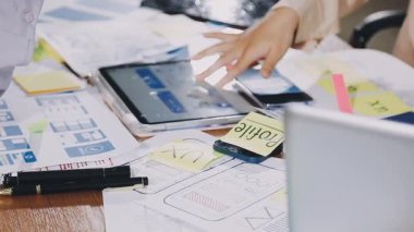 Ofisinde cep telefonu ve tableti olan genç bir kadın.