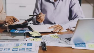 İş kadını ofiste hesap makinesi ve dizüstü bilgisayarla çalışıyor.