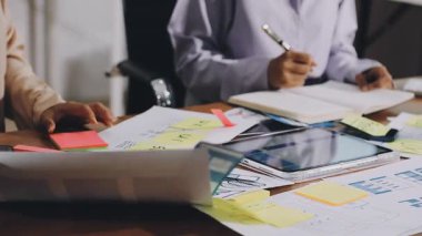 İş adamı, ofiste dizüstü bilgisayarda toplanan ve görüşülen finansal belgeleri analiz ediyor..