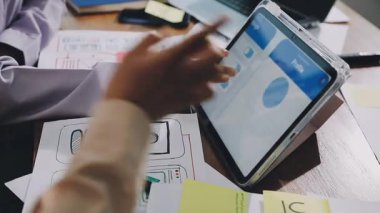 İş adamı masadaki iş planıyla birlikte dijital tablet kullanıyor