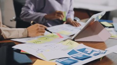 Ofisteki grafikleri ve grafikleri analiz eden bir iş adamı. Ofiste çalışan iş adamları