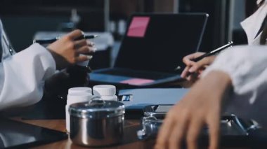 Doktor ofiste dizüstü bilgisayar ve tablet üzerinde çalışıyor..