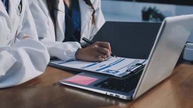 Tıbbi belgeleri ve bilgisayarı olan bir doktor.