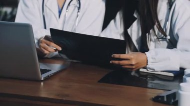 Hastane ofisinde laptoplu ve tabletli bir doktor.