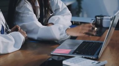 İşyerinde dizüstü bilgisayarı ve steteskopu olan bir doktor.