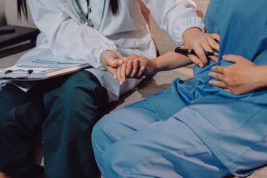 Doktor, klinikteki masada otururken hasta kadına güven veriyor, sadece eller. İlaç ve en iyi hizmet