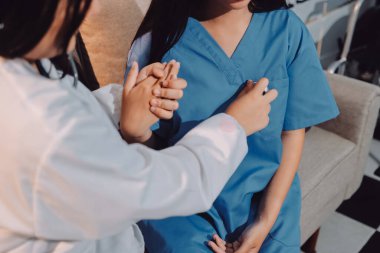 Bir doktor hastasının kalp atışlarını kontrol etmek için steteskop kullanır. Hastaların her yıl sağlık kontrolünden ya da kardiyologdan sağlık kontrolünden geçmeleri gerekir..