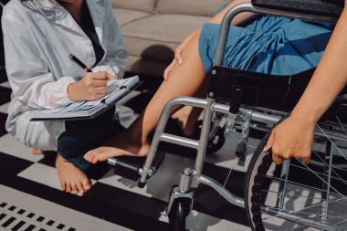 Kadın hasta stoklarını kontrol eden fizyoterapist.