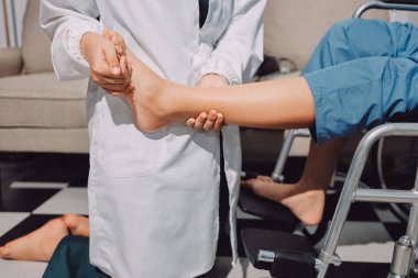 Kadın hasta stoklarını kontrol eden fizyoterapist.