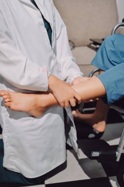 Kadın hasta stoklarını kontrol eden fizyoterapist.