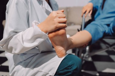 Kadın hasta stoklarını kontrol eden fizyoterapist.