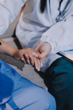 Doktor, klinikteki masada otururken hasta kadına güven veriyor, sadece eller. İlaç ve en iyi hizmet