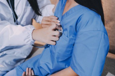 Bir doktor hastasının kalp atışlarını kontrol etmek için steteskop kullanır. Hastaların her yıl sağlık kontrolünden ya da kardiyologdan sağlık kontrolünden geçmeleri gerekir..