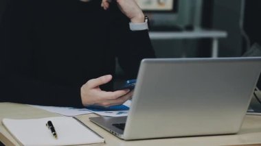 Ofiste çalışan işadamı elinde bilgisayar ve belgelerle.