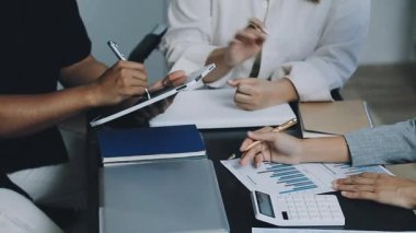 İş adamları ofisteki bir dizüstü bilgisayardaki finansal çizelge ve grafikleri tartışıyor ve analiz ediyor. Takım çalışması ve beyin fırtınası konsepti