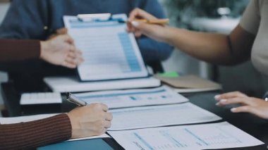 Bir grup genç iş adamı birlikte çalışıyor ve iş projesini tartışıyorlar.