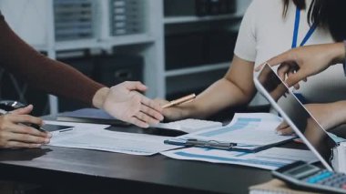 Ofiste çalışan hesap makineli genç bir kadın.