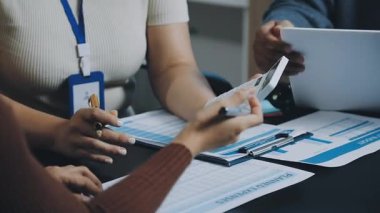 Bir grup iş adamı ofiste bir toplantı üzerinde çalışıyor.