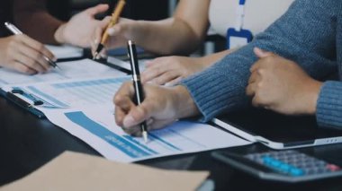 Genç iş adamları ofisteki masada iş ve yazı tartışıyorlar.