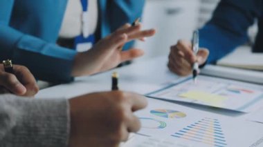 Ekonomik planı tartışan iş adamlarının yakın plan görüşü ve ofiste yapılan toplantıda mali grafiklerin analiz edilmesi