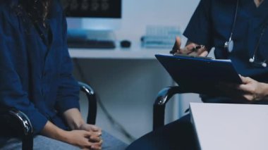 Doktorlar dijital tablet üzerinde tıbbi sonuçları tartışıyor ve analiz ediyorlar.