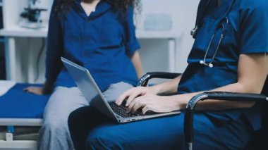 Hastanede dizüstü bilgisayarı ve steteskopu olan kadın doktor.