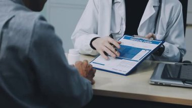 Doktor sonuçları tartışırken hastaya reçete gösteriyor